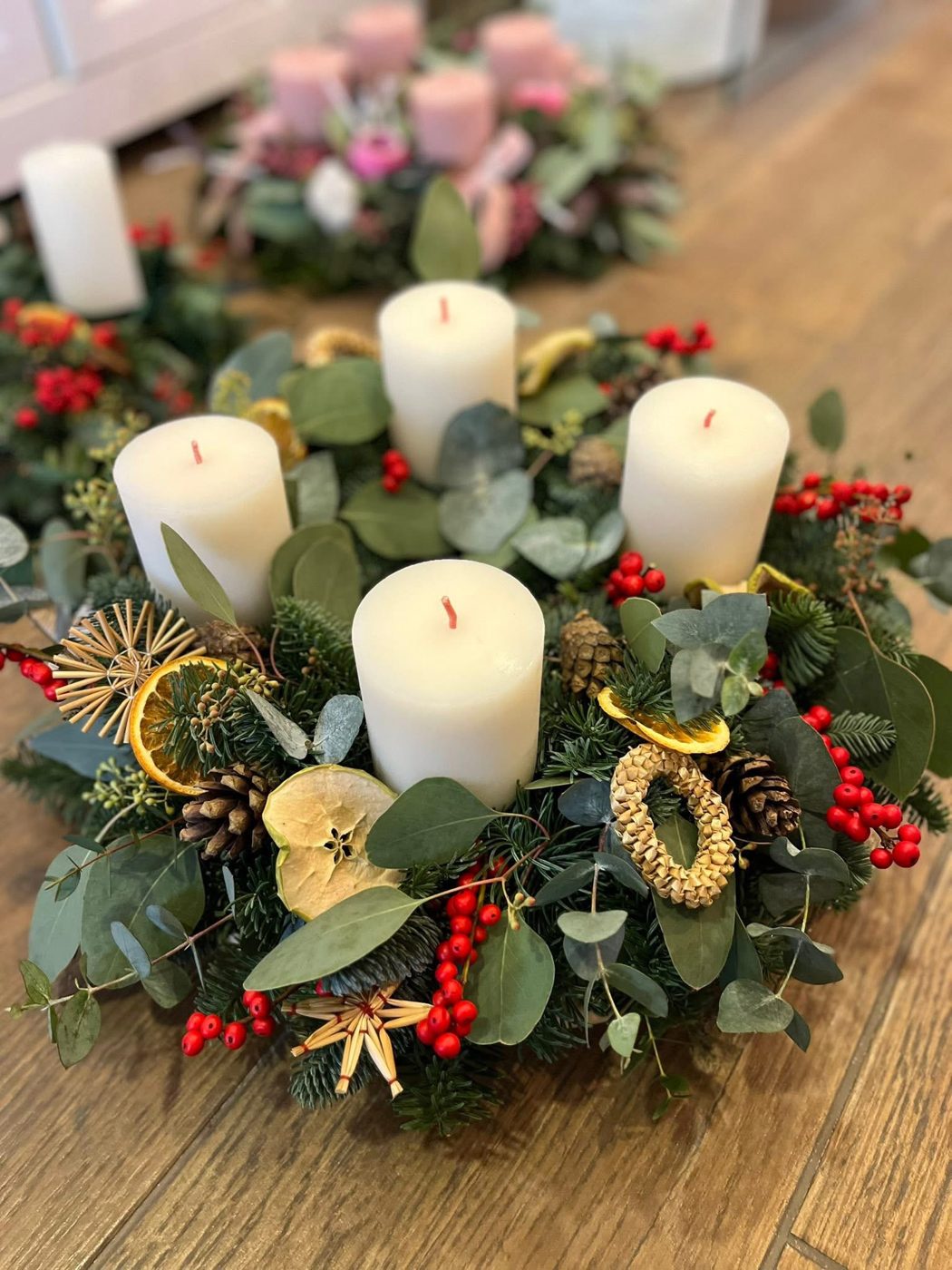 Adventný veniec s bielymi sviečkami a bobuľami